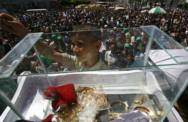 Fondos extranjeros, donativos, impuestos y criptomonedas: qué se sabe sobre cómo se financia Hamás 6 Un niño palestino y una urna con dinero y joyas.