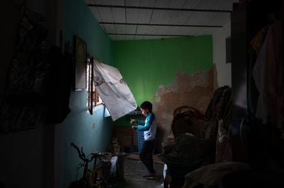 Juan Carlos, hermano menor de Omar, juega desde una ventana de su casa. 