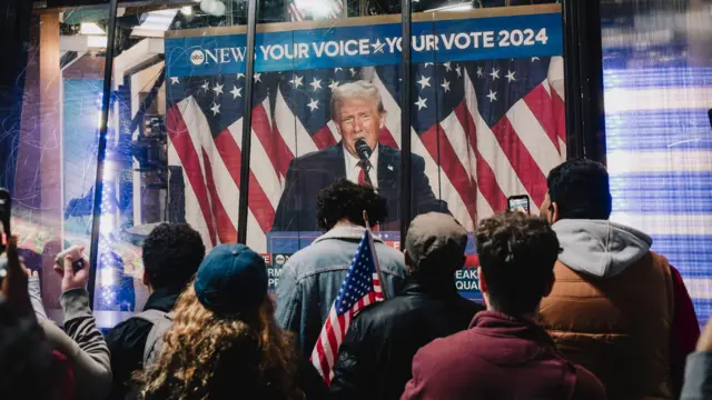 “El discurso duro de Trump encajó bien con la imagen de macho que intenta proyectar y eso le gusta a mucha gente” 2 Gente mirando a Trump en una pantalla