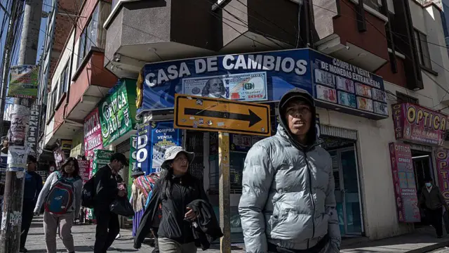 Tres claves para entender por qué el MAS perdió en Bolivia tras casi 20 años en el poder 3 Personas caminan frente a casas de cambio en el centro de El Alto, Bolivia, el jueves 14 de agosto de 2025.