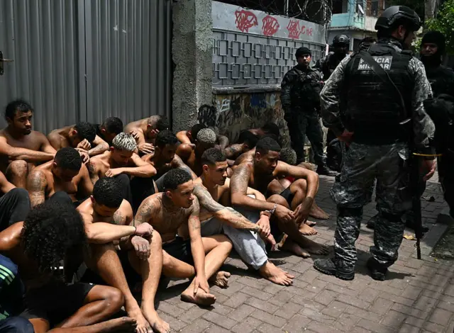 Agentes de policía custodian a presuntos delincuentes arrestados durante la Operación Contención en la favela Vila Cruzeiro, en el complejo Penha, Río de Janeiro, Brasil, el 28 de octubre de 2025. 